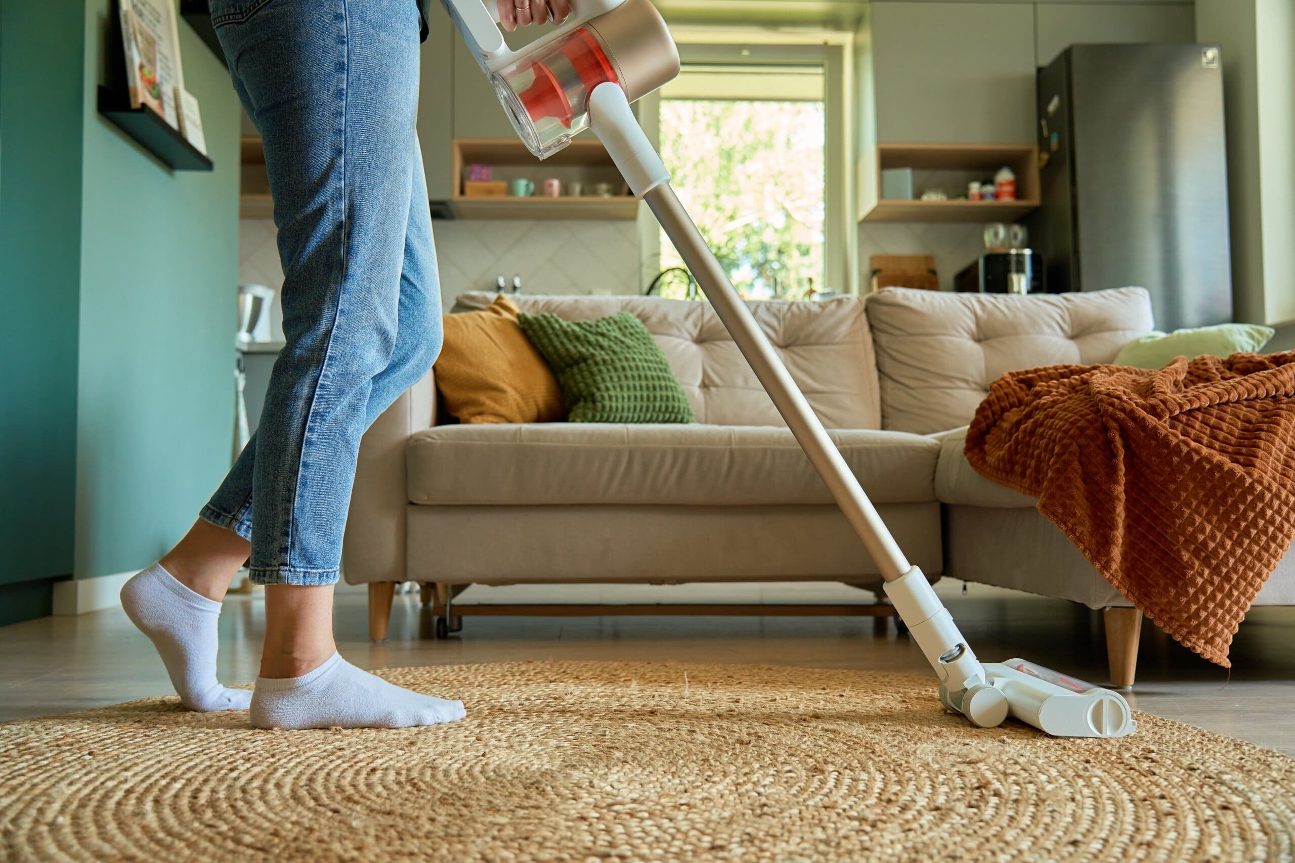 Woman's legs and a hoover cleaning a living room.